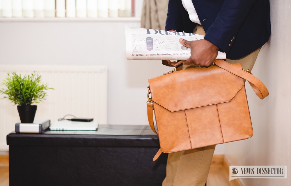 Man carrying a business bag and a newspaper